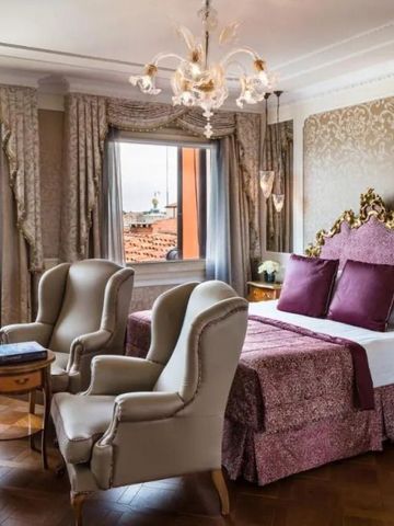 Luxuriöse Suite mit zwei Sesseln, großen Fenstern und edler Bettwäsche