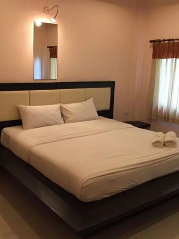 Gemütliches Schlafzimmer mit großem Doppelbett und elegantem Spiegel