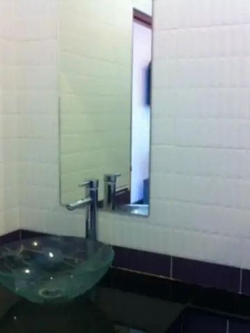 Modernes Bad mit eleganter Glasschale und Wandspiegel