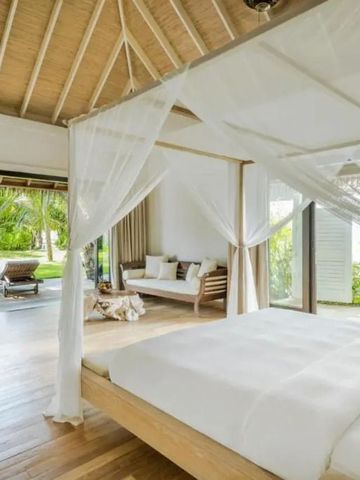 Luftiges Schlafzimmer mit Himmelbett und Terrasse mit Blick auf den Garten