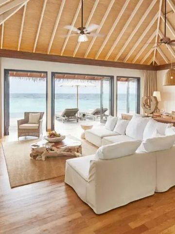 Luxuswohnzimmer mit großen Fenstern zum Strand und moderner Einrichtung