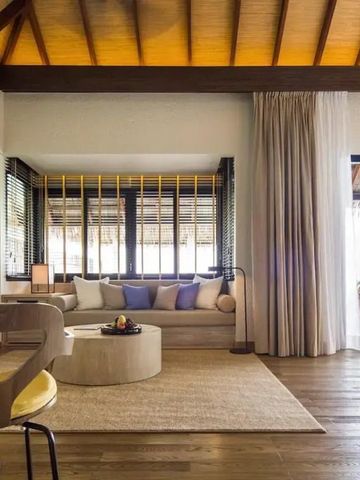 Luxuriöse Suite mit Holzboden, bequemen Sofas und einem Meerblick über eine private Terrasse