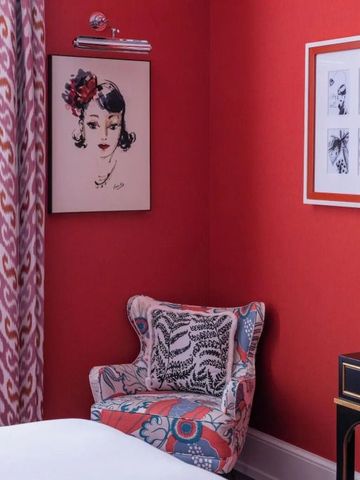 Elegante Ecke eines Hotelzimmers mit Kunstwerken und stilvollem Stuhl