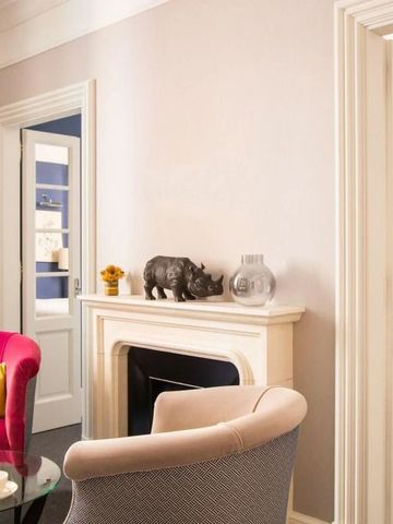 Wohnbereich eines Hotelzimmers mit Kamin und bequemen Sesseln