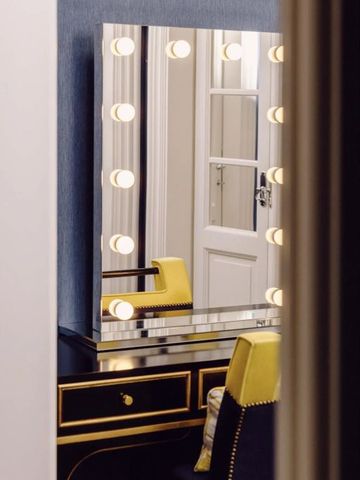 Moderner Schminktisch mit blauem Hocker in einem luxuriösen Hotelzimmer