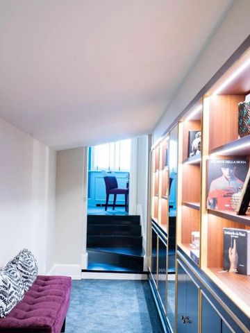 Hotelkorridor mit dekorativen Regalen und einem gemütlichen Sitzbereich