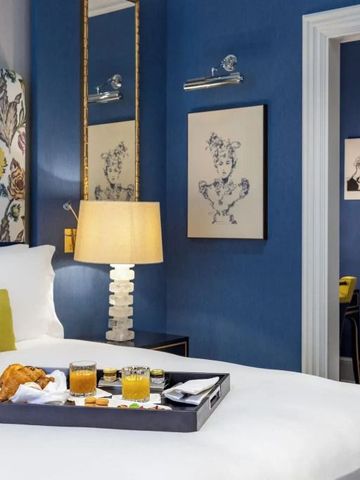Elegantes Zimmer mit blauem Thema und Tablett mit Frühstück auf dem Bett.