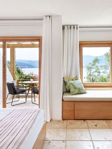 Zimmer mit Ausblick auf die Terrasse und das Meer mit bequemen Sitzgelegenheiten