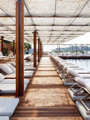 Luxuriöse Liegeflächen auf einem überdachten Holzsteg am Wasser