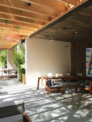 Schattige Terrasse mit Holzmöbeln und künstlerischer Dekoration