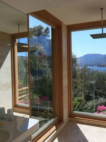 Modernes Badezimmer mit Panoramafenster und Seeblick