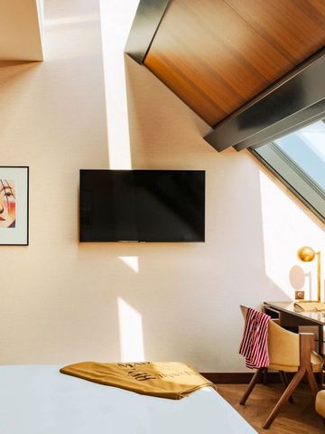 Modernes Hotelzimmer mit Dachfenster und stilvollem Schreibtisch