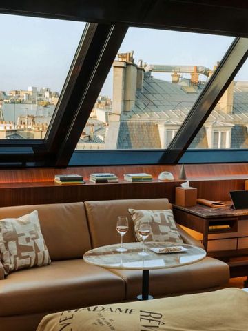Elegantes Zimmer mit großem Panoramafenster und Ausblick auf Pariser Dächer