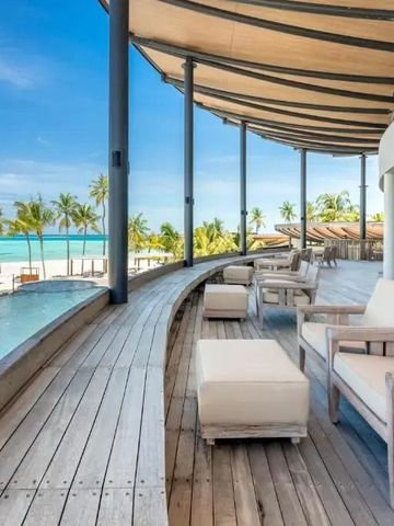 Überdachte Terrasse mit Blick auf Strand und Palmen