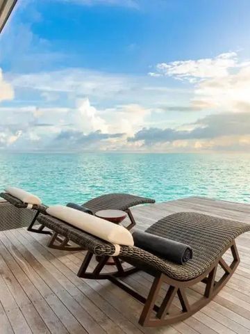 Sonnenliegen auf Holzdeck am Meer