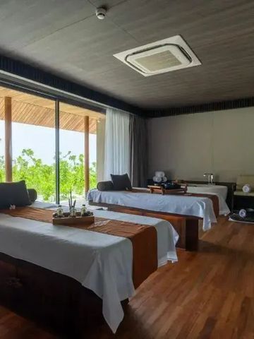 Heller Spa-Raum mit zwei Massageliegen und Blick nach draußen