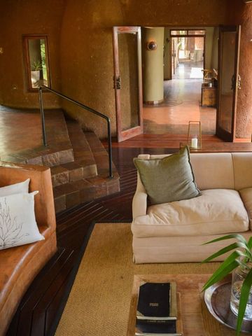 Elegantes Wohnzimmer mit naturverbundenem Design und großer Fensterfront.