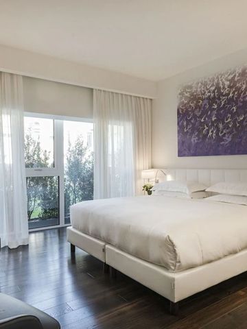 Luxuriöses Hotelzimmer mit Kingsize-Bett und großer Fensterfront