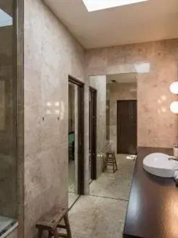 Modernes Bad mit Marmorwänden und eleganter Beleuchtung