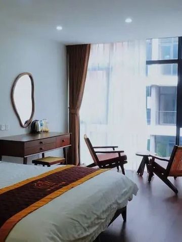 Helles Hotelzimmer mit großem Fenster und zwei Stühlen