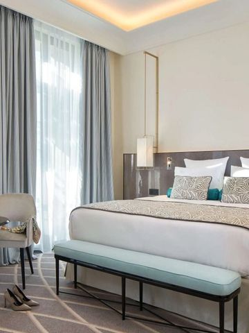 Helles, modernes Hotelzimmer mit Kingsize-Bett und eleganter Einrichtung