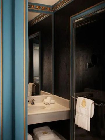 Stilvolles Badezimmer mit blau-goldenen Akzenten und elegantem Waschtisch