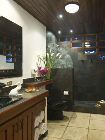 Modernes Badezimmer mit dunklen Fliesen und hölzernem Waschtisch