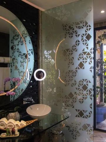 Luxuriöses Badezimmer mit verzierten Glaswänden und Außenblick