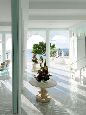 Heller Raum mit Meerblick und dekorativen Blumenarrangements