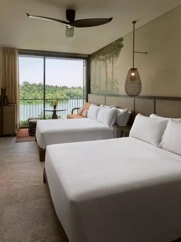 Zimmer mit zwei Betten und Balkon mit Flussblick