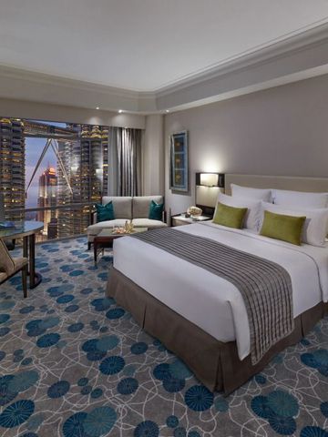 Geräumiges Zimmer mit Kingsize-Bett und Balkonblick auf die moderne Architektur von Kuala Lumpur