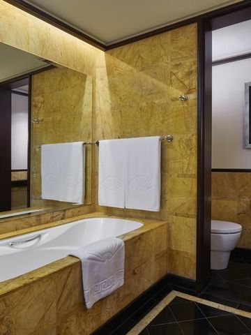 Edles Badezimmer mit Marmorverkleidung und geräumiger Badewanne