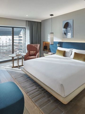 Luxuriöses Schlafzimmer mit großem Bett und komfortablem Sessel.