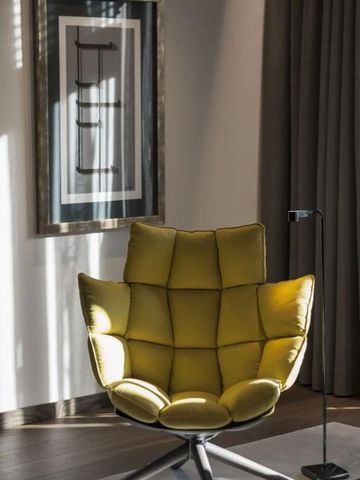 Moderner gelber Sessel in luxuriösem Ambiente mit Kunst an der Wand