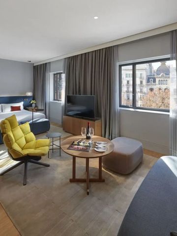 Geräumige Suite mit großem Bett und Stadtblick
