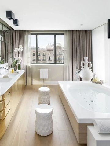 Luxuriöses Badezimmer mit goldenen Akzenten und großem Fenster