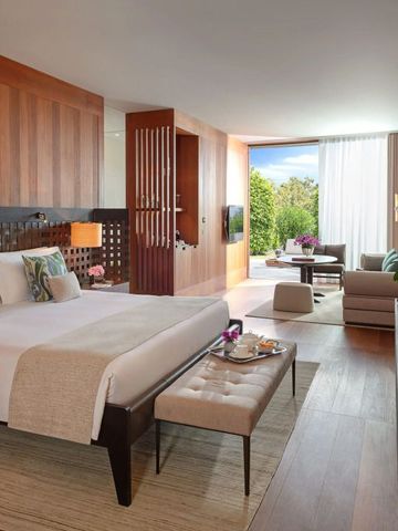 Helles Hotelzimmer mit luxuriösem Bett und Sitzbereich