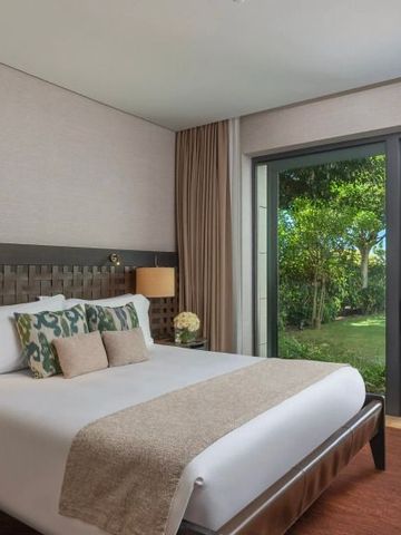 Modernes Hotelzimmer mit Gartenblick durch große Fenster