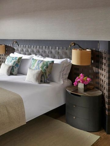 Gemütliches Bett im luxuriösen Hotelzimmer mit Blumen