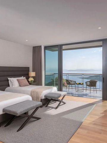 Luxuriöses Hotelzimmer mit zwei Einzelbetten und Balkon mit Meerblick