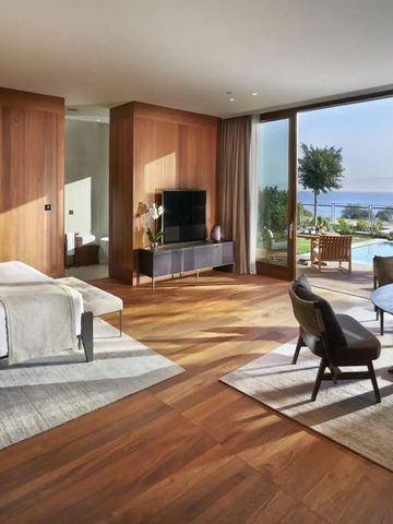 Geräumige Suite mit Holzverkleidung großem Fenster und Blick auf Garten und Ozean