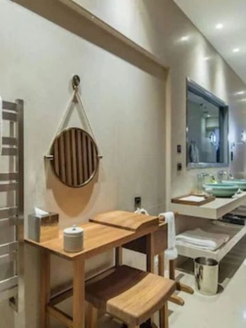 Modernes Badezimmer mit Holzdetails und stilvollem Spiegel im Mandarin Oriental Bodrum