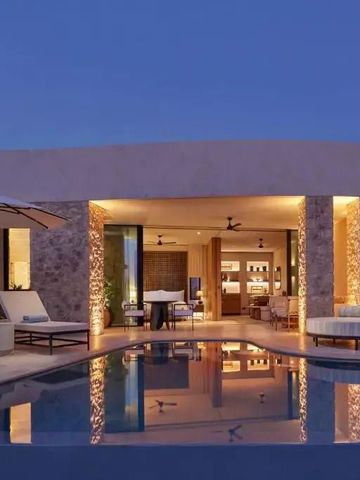 Luxuriöse Villa bei Nacht mit beleuchtetem Pool und Terrasse