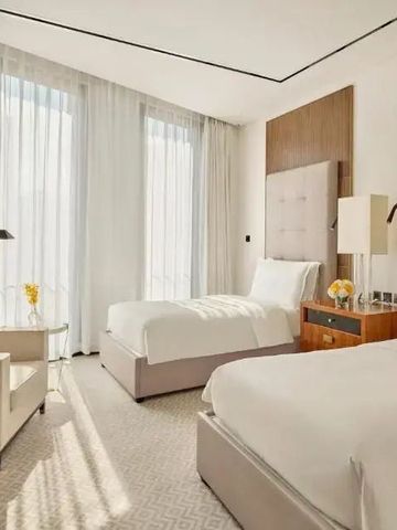 Helles Hotelzimmer mit zwei Einzelbetten und großen Fenstern