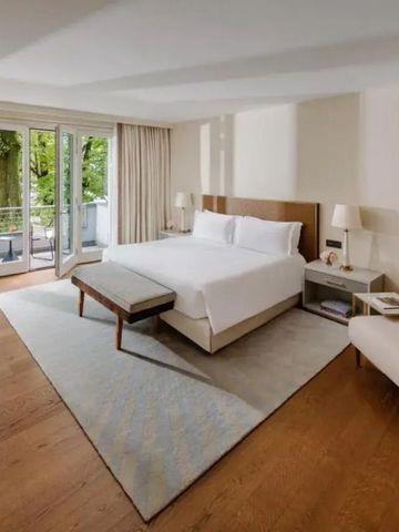 Helles Luxuszimmer mit einem großen Bett und Zugang zu einem Balkon mit Blick ins Grüne