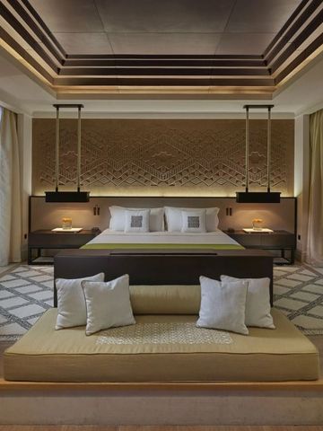 Großzügiges Schlafzimmer mit stilvoller Beleuchtung und dekorativer Wand