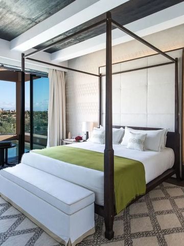 Helles Schlafzimmer mit Himmelbett und Balkonblick