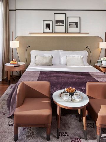 Einladendes Zimmer mit gepolsterten Stühlen und edler Bettwäsche im Mandarin Oriental, Milan
