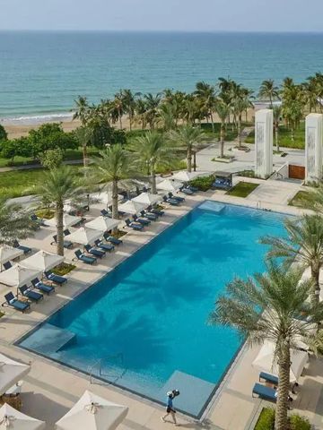 Panoramablick auf den Pool und den Strand im Hotelgarten.