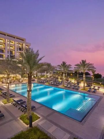 Stimmungsvolle Abendansicht des beleuchteten Hotelpools bei Sonnenuntergang.